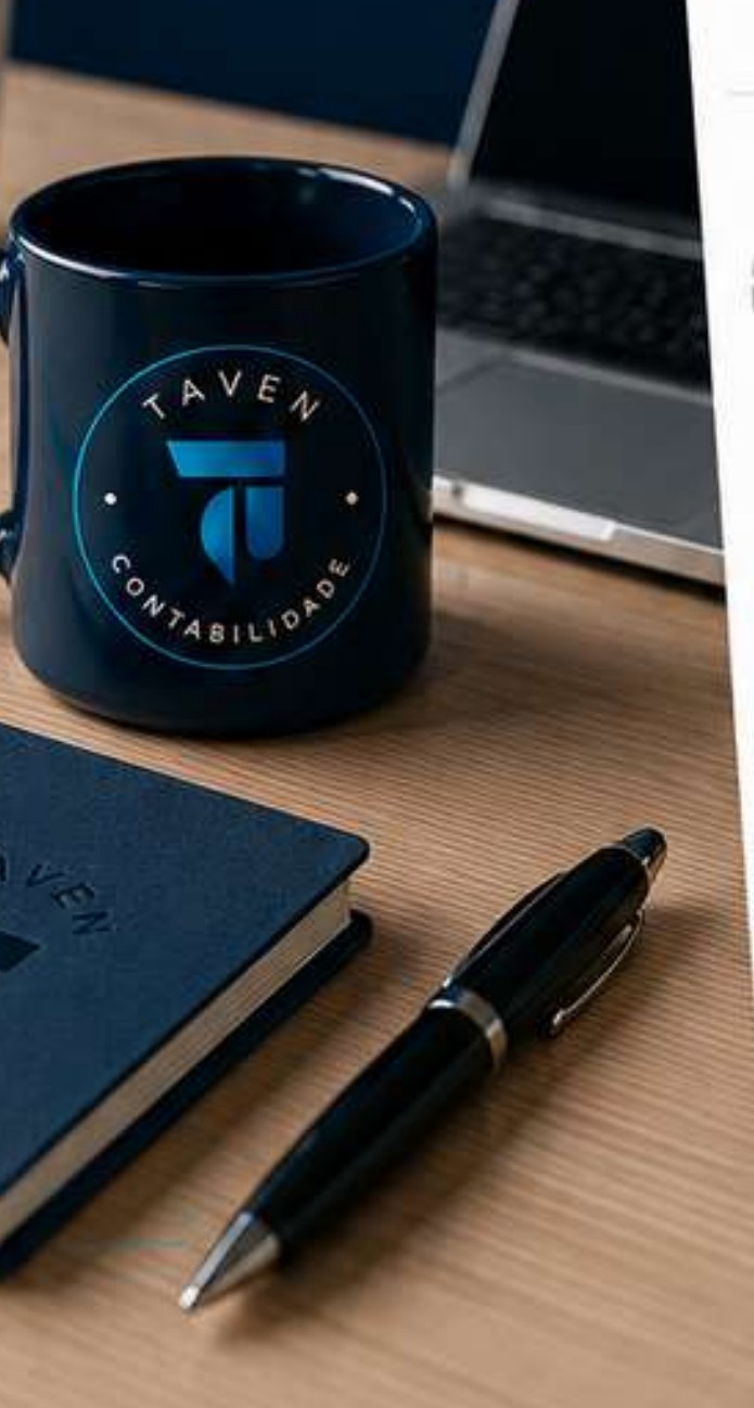 Caneca e caderno da marca Taven sobre a mesa